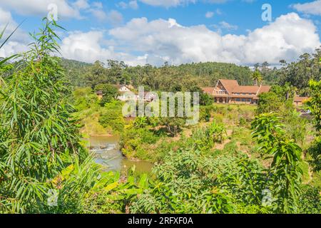 Rivière Vohitra traversant le village Andasibe, en arrière-plan la gare, Madagascar Banque D'Images