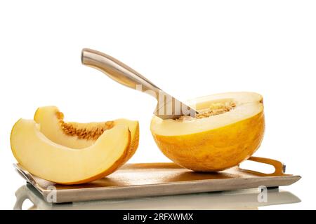 Un melon jaune coupé en tranches sur un plateau en métal avec un couteau en métal, macro, isolé sur fond blanc. Banque D'Images