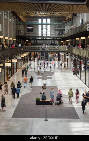 Intérieur de la centrale électrique de Battersea montrant des gens qui passent devant des unités de vente au détail dans le cadre du réaménagement, Londres, Royaume-Uni Banque D'Images