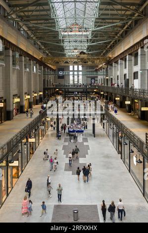 Intérieur de la centrale électrique de Battersea montrant des gens qui passent devant des unités de vente au détail dans le cadre du réaménagement, Londres, Royaume-Uni Banque D'Images