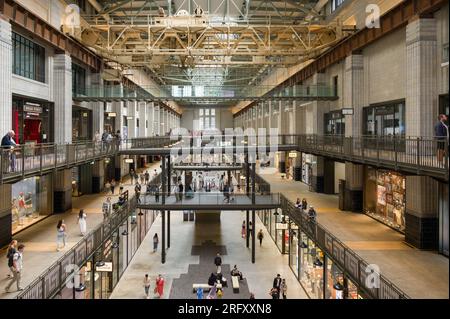 Intérieur de la centrale électrique de Battersea montrant des gens qui passent devant des unités de vente au détail dans le cadre du réaménagement, Londres, Royaume-Uni Banque D'Images