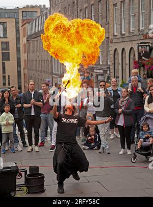 Edinburgh Festival Fringe Street spectacles, Écosse, Royaume-Uni. 6 août 2023. Le High Street Royal Mile, le Tron et le Mound avaient des artistes de rue professionnels qui busaient, certains plus chauds que d'autres avec du feu et des acteurs de spectacles faisant la promotion de leurs performances. Le temps était plus doux avec une température d'environ 21 degrés centigrades une fois que le soleil est apparu, bien qu'il y ait eu une forte averse en fin d'après-midi. Photo : Hachikun souffle une boule de feu sur le terrain de Tron. Crédit : Archwhite/alamy Live News. Banque D'Images
