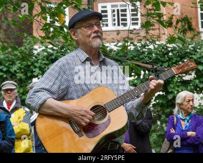 Londres, Royaume-Uni. 6 août 2023 Hugh Goodachre joue de la guitare et chante. 78 ans après que les États-Unis ont explosé des bombes atomiques dans les villes japonaises d’Hiroshima et de Nagaski, le CND londonien s’est réuni au cerisier d’Hiroshima sur la place Tavistock pour se souvenir des plus de 350 000 personnes tuées immédiatement ou qui sont mortes des bombardements dans les mois suivants. Les intervenants ont appelé le gouvernement britannique à abandonner les armes nucléaires et à signer le traité de l'ONU interdisant les armes nucléaires. Peter Marshall/Alamy Live News. Banque D'Images