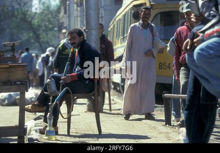 Les gens fument de la shisha dans une rue de la ville d'Alexandrie sur la mer Méditerranée en Egypte en Afrique du Nord. Égypte, Alexandrie, mars 2000 Banque D'Images