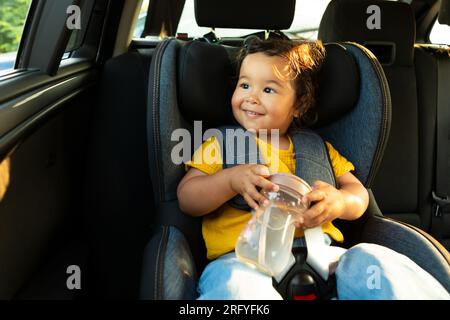 Japanese Toddler Girl assis avec confort dans la chaise dans l'automobile Banque D'Images