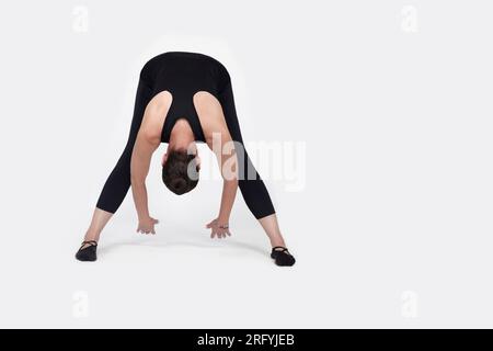 Trauma spécialisé libérant des exercices pour les personnes âgées, entraîneur de femme de 55 ans posant pour des exercices. Pose des ischio-jambiers, dans le studio isolé sur Banque D'Images