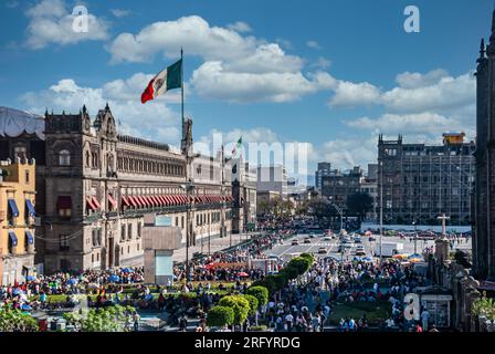 Une vue panoramique capture une rue animée près du Zócalo à Mexico. Une partie de la place emblématique et le majestueux Palacio Nacional sont visibles. T Banque D'Images