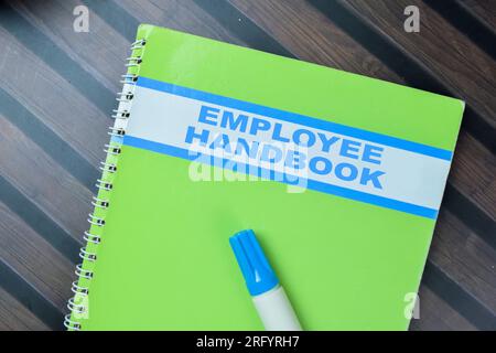 Concept du manuel de l'employé écrire sur le livre isolé sur la table en bois. Banque D'Images