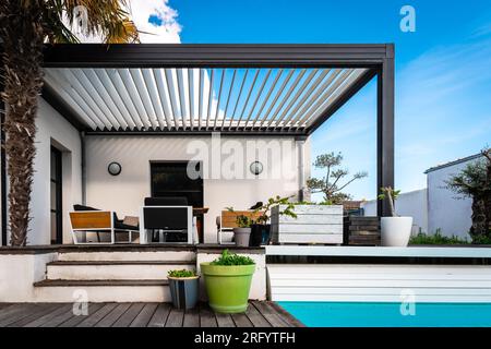 structure pergola moderne dans une maison contemporaine entourée d'un jardin et d'une piscine Banque D'Images