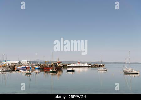 Bateaux, yachts et chalutiers dans le port de Mallaig sur un après-midi calme et ensoleillé avec le CalMac car Ferry MV Loch Fyne à la jetée prêt à naviguer à Armadale Banque D'Images