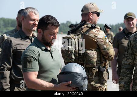 Le président ukrainien Volodymyr Zelenskyy rencontre des militaires de l'armée de l'air ukrainienne, qui lui ont remis un casque de pilote signé, alors qu'ils honorent la Journée de l'armée de l'air des forces armées ukrainiennes le dimanche 6 août 2023. Zelenskyy a observé plusieurs armes fournies par des partenaires occidentaux, dont des missiles air-sol ZUNI, des missiles Storm Shadow (dont il a signé) et des missiles anti-radiation AGM HARM avant de passer du temps dans un simulateur de vol fourni à l'Ukraine par la République tchèque pour former des pilotes à l'exploitation d'avions F-16 de style occidental. Photo via Ukrainian Presidenti Banque D'Images