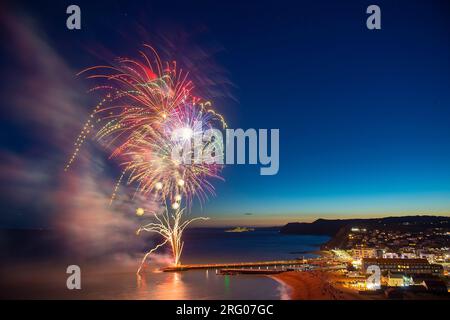 West Bay, Dorset, Royaume-Uni. 6 août 2023. UK Météo. Les feux d'artifice illuminent le ciel nocturne presque sombre au-dessus de la station balnéaire de West Bay dans le Dorset pour la finale du West Bay Day annuel à la fin d'une chaude journée claire. Crédit photo : Graham Hunt/Alamy Live News Banque D'Images