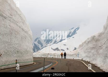 Murs de neige le long de la route alpine Tateyama Kurobe partiellement cachés par les nuages, Toyama et Nagano, Japon Banque D'Images