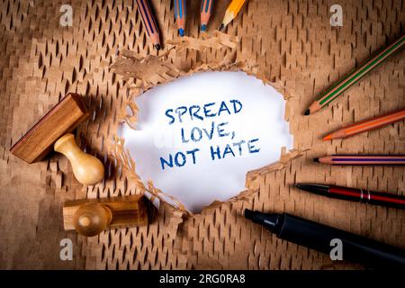Répandez l'amour, pas la haine. Papier cartonné déchiré et fournitures de bureau. Banque D'Images