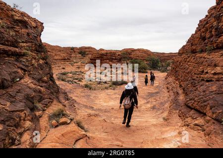 Les randonneurs sur le Kings Canyon Rim marchent en sortant de Priscilla crack vers une région ouverte sur le côté nord du canyon. Parc national de Watarrka, nord Banque D'Images