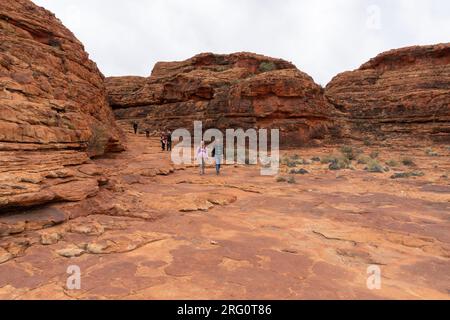 Les randonneurs sur le Kings Canyon Rim marchent en sortant de Priscilla crack vers une région ouverte sur le côté nord du canyon. Parc national de Watarrka, nord Banque D'Images