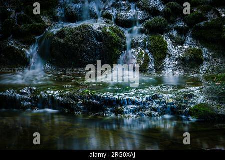 cascade sombre profondément dans les bois en longue exposition Banque D'Images