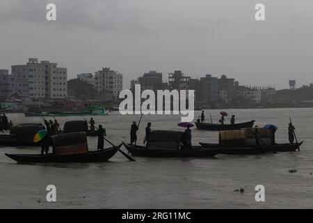 Narayanganj, Dhaka, Bangladesh. 7 août 2023. Les habitants traversent la rivière Shitalakhya par des bateaux en bois à Narayanganj, au Bangladesh, un jour de pluie. La saison de la mousson apporte de fortes précipitations au pays. En fait, environ 80% des précipitations annuelles du Bangladesh se produisent de juin à octobre, et à la fin de la saison de la mousson, près d'un tiers du pays est sous l'eau. Le Bangladesh est un pays très humide, recevant en moyenne environ 2 200 millimètres (mm) de précipitations par an. (Image de crédit : © Joy Saha/ZUMA Press Wire) USAGE ÉDITORIAL SEULEMENT! Non destiné à UN USAGE commercial ! Banque D'Images