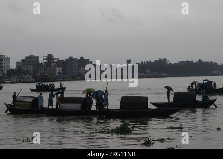 Narayanganj, Dhaka, Bangladesh. 7 août 2023. Les habitants traversent la rivière Shitalakhya par des bateaux en bois à Narayanganj, au Bangladesh, un jour de pluie. La saison de la mousson apporte de fortes précipitations au pays. En fait, environ 80% des précipitations annuelles du Bangladesh se produisent de juin à octobre, et à la fin de la saison de la mousson, près d'un tiers du pays est sous l'eau. Le Bangladesh est un pays très humide, recevant en moyenne environ 2 200 millimètres (mm) de précipitations par an. (Image de crédit : © Joy Saha/ZUMA Press Wire) USAGE ÉDITORIAL SEULEMENT! Non destiné à UN USAGE commercial ! Banque D'Images