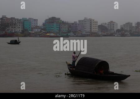 Narayanganj, Dhaka, Bangladesh. 7 août 2023. Les habitants traversent la rivière Shitalakhya par des bateaux en bois à Narayanganj, au Bangladesh, un jour de pluie. La saison de la mousson apporte de fortes précipitations au pays. En fait, environ 80% des précipitations annuelles du Bangladesh se produisent de juin à octobre, et à la fin de la saison de la mousson, près d'un tiers du pays est sous l'eau. Le Bangladesh est un pays très humide, recevant en moyenne environ 2 200 millimètres (mm) de précipitations par an. (Image de crédit : © Joy Saha/ZUMA Press Wire) USAGE ÉDITORIAL SEULEMENT! Non destiné à UN USAGE commercial ! Banque D'Images