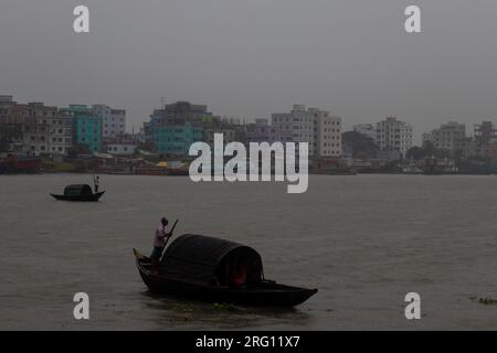 Narayanganj, Dhaka, Bangladesh. 7 août 2023. Les habitants traversent la rivière Shitalakhya par des bateaux en bois à Narayanganj, au Bangladesh, un jour de pluie. La saison de la mousson apporte de fortes précipitations au pays. En fait, environ 80% des précipitations annuelles du Bangladesh se produisent de juin à octobre, et à la fin de la saison de la mousson, près d'un tiers du pays est sous l'eau. Le Bangladesh est un pays très humide, recevant en moyenne environ 2 200 millimètres (mm) de précipitations par an. (Image de crédit : © Joy Saha/ZUMA Press Wire) USAGE ÉDITORIAL SEULEMENT! Non destiné à UN USAGE commercial ! Banque D'Images