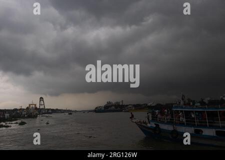 Narayanganj, Dhaka, Bangladesh. 7 août 2023. Les habitants traversent la rivière Shitalakhya par des bateaux en bois à Narayanganj, au Bangladesh, un jour de pluie. La saison de la mousson apporte de fortes précipitations au pays. En fait, environ 80% des précipitations annuelles du Bangladesh se produisent de juin à octobre, et à la fin de la saison de la mousson, près d'un tiers du pays est sous l'eau. Le Bangladesh est un pays très humide, recevant en moyenne environ 2 200 millimètres (mm) de précipitations par an. (Image de crédit : © Joy Saha/ZUMA Press Wire) USAGE ÉDITORIAL SEULEMENT! Non destiné à UN USAGE commercial ! Banque D'Images