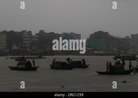 Narayanganj, Dhaka, Bangladesh. 7 août 2023. Les habitants traversent la rivière Shitalakhya par des bateaux en bois à Narayanganj, au Bangladesh, un jour de pluie. La saison de la mousson apporte de fortes précipitations au pays. En fait, environ 80% des précipitations annuelles du Bangladesh se produisent de juin à octobre, et à la fin de la saison de la mousson, près d'un tiers du pays est sous l'eau. Le Bangladesh est un pays très humide, recevant en moyenne environ 2 200 millimètres (mm) de précipitations par an. (Image de crédit : © Joy Saha/ZUMA Press Wire) USAGE ÉDITORIAL SEULEMENT! Non destiné à UN USAGE commercial ! Banque D'Images