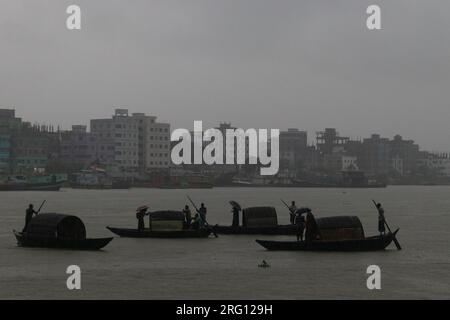 Narayanganj, Dhaka, Bangladesh. 7 août 2023. Les habitants traversent la rivière Shitalakhya par des bateaux en bois à Narayanganj, au Bangladesh, un jour de pluie. La saison de la mousson apporte de fortes précipitations au pays. En fait, environ 80% des précipitations annuelles du Bangladesh se produisent de juin à octobre, et à la fin de la saison de la mousson, près d'un tiers du pays est sous l'eau. Le Bangladesh est un pays très humide, recevant en moyenne environ 2 200 millimètres (mm) de précipitations par an. (Image de crédit : © Joy Saha/ZUMA Press Wire) USAGE ÉDITORIAL SEULEMENT! Non destiné à UN USAGE commercial ! Banque D'Images