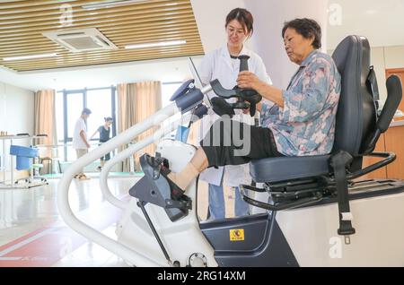 HUZHOU, CHINE - le 7 AOÛT 2023 - un homme âgé est escorté par du personnel médical pendant une formation de réadaptation à la « Maison de réadaptation », une communauté Banque D'Images