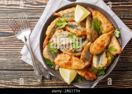 Assiette d'anchois frits avec gros plan citron sur la table. Vue de dessus horizontale Banque D'Images