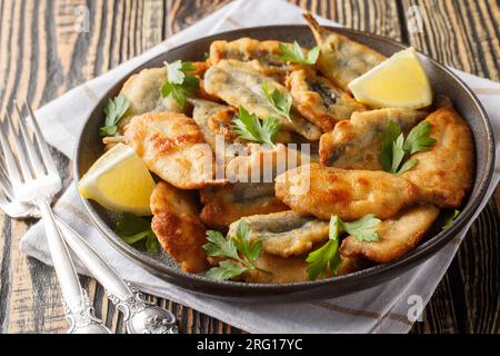 Assiette d'anchois frits avec gros plan citron sur la table. Horizontal Banque D'Images