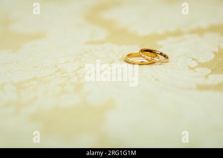 Détail des anneaux de mariage dorés l'un sur l'autre qui symbolisent l'amour et l'Union d'un couple. Banque D'Images