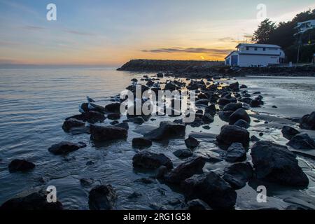 Sumner Beach à Christchurch , Nouvelle-Zélande , où le soleil se couche sur l'océan pacifique Banque D'Images