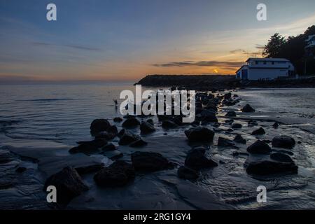 Sumner Beach à Christchurch , Nouvelle-Zélande , où le soleil se couche sur l'océan pacifique Banque D'Images