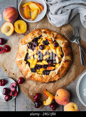 Vue de dessus de pêche fraîchement cuit et dessert galette de cerises. Banque D'Images