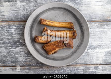 côtes de porc sur une assiette en bois sur un fond en bois gris. Vue de dessus, pose à plat, gros plan. Banque D'Images