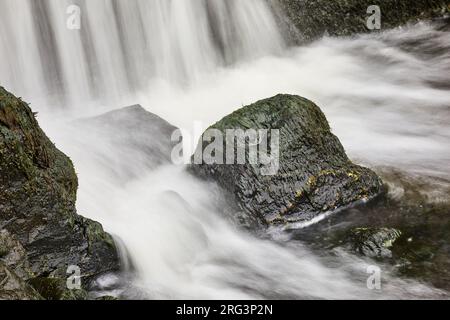 L'eau s'écrase sur les rochers à la base d'une cascade verticale, sur la côte à Speke's Mill Mouth, près de Hartland Quay, Devon, Grande-Bretagne. Banque D'Images