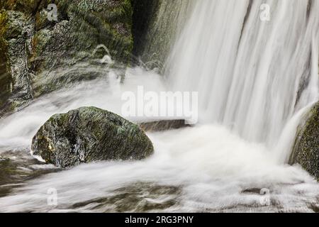 L'eau s'écrase sur les rochers à la base d'une cascade verticale, sur la côte à Speke's Mill Mouth, près de Hartland Quay, Devon, Grande-Bretagne. Banque D'Images