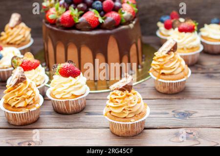 Magnifiques cupcakes au beurre de cacahuète, caramel salé et barre de chocolat sur fond de bois rustique Banque D'Images