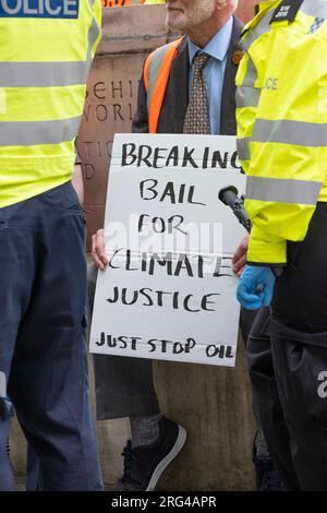 Just Stop Oil militants sont détenus par la police à Londres, faisant campagne pour que le gouvernement arrête toute licence et production future de combustibles fossiles. Banque D'Images