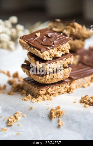 Barres ou carrés de flocons d'avoine à haute énergie, faits avec des flocons d'avoine, beurre d'arachide, miel, huile de coco, et des noix de cajou, garnies de chocolat. Banque D'Images