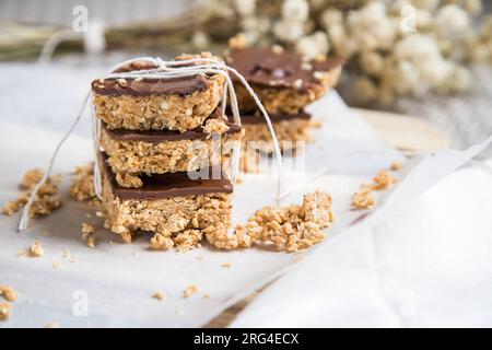 Barres ou carrés de flocons d'avoine à haute énergie, faits avec des flocons d'avoine, beurre d'arachide, miel, huile de coco, et des noix de cajou, garnies de chocolat. Banque D'Images