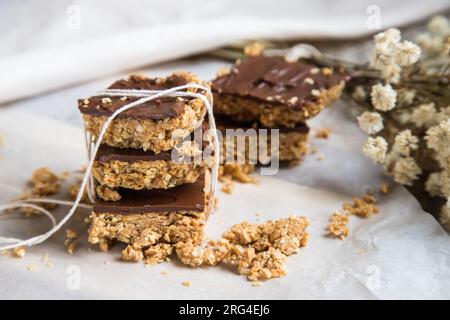 Barres ou carrés de flocons d'avoine à haute énergie, faits avec des flocons d'avoine, beurre d'arachide, miel, huile de coco, et des noix de cajou, garnies de chocolat. Banque D'Images