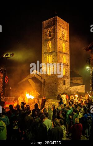 Voisins passant devant l'église de la Nativitat de Durro sur la descente des Falles de 2023 (Vall de Boí, Lleida, Catalogne, Espagne, Pyrénées) Banque D'Images