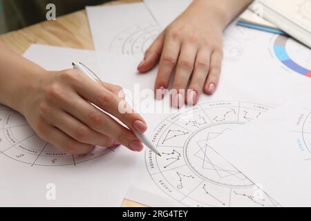 Astrologue utilisant la roue du zodiaque pour la prévision de destin à table, closeup. Dire la fortune Banque D'Images