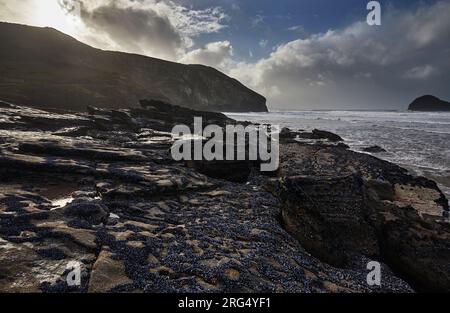 Un rivage rocheux et sablonneux à marée basse, à Trebarwith Strand, près de Tintagel, sur la côte atlantique des Cornouailles, en Grande-Bretagne. Banque D'Images