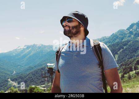 homme touristique barbu millenial portant un chapeau de seau, avec le trekking de sac à dos dans les montagnes Banque D'Images