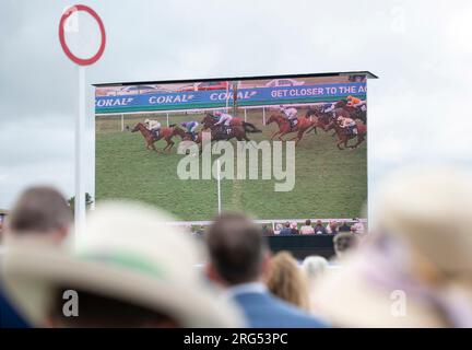 Spectateurs regardant l'action sur grand écran au Qatar Goodwood Festival Meeting 2023 à Goodwood Racecourse, Chichester Banque D'Images