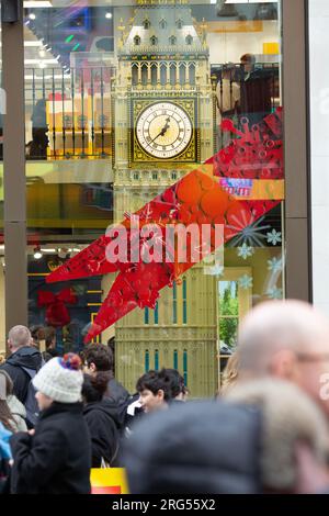 Les gens passent devant une maquette de la tour Elizabeth, qui abrite Big Ben, exposée dans une vitrine dans le centre de Londres, le jour du nouvel an. Banque D'Images