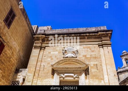 Birgu, Malte Oratoire de la Sainte Croix extérieur avec détail de décoration en calcaire et marbre à la vieille ville de Citta Vittoriosa, sous un ciel bleu. Banque D'Images